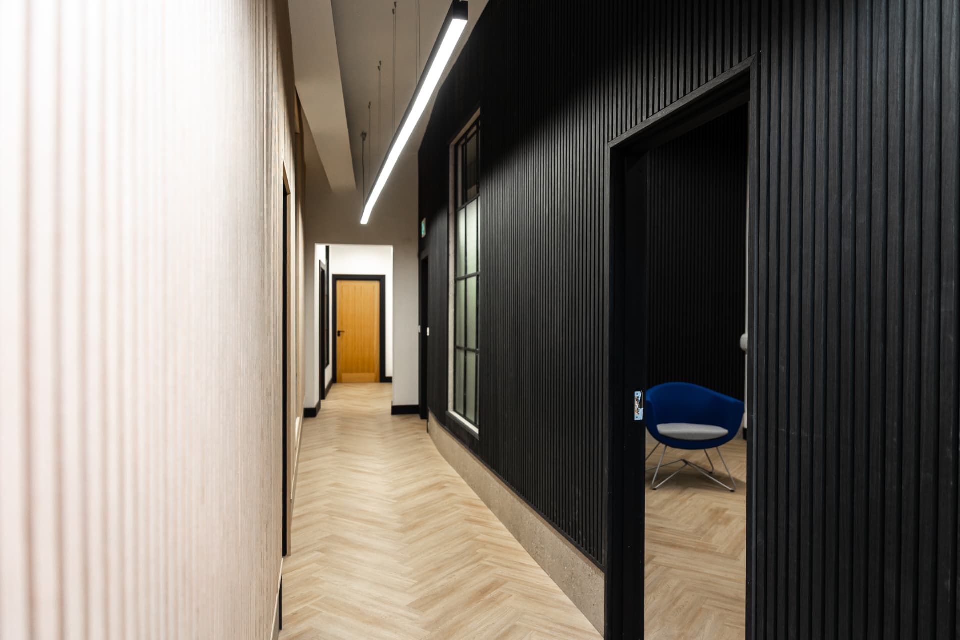 Workpoint corridor with blue chairs visible in a side room