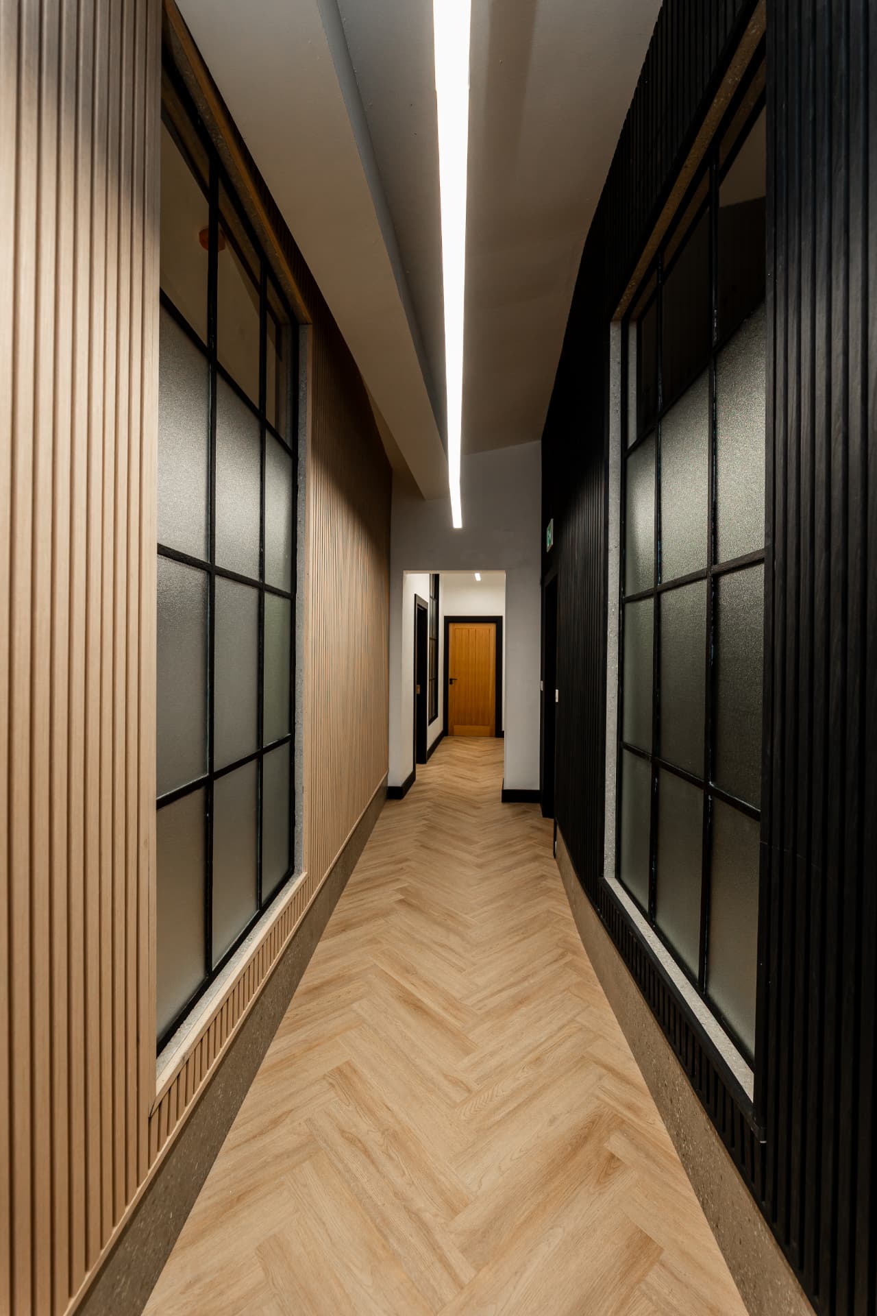Workpoint corridor with vertical wood slats and recessed lighting